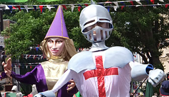 St George's Church. Giant colourful figures of St George and maiden with huge mobile arms dominate the street.